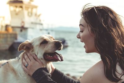 Portrait of woman with dog at water