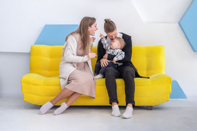 Rear view of woman sitting on sofa at home