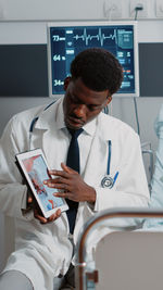 Doctor showing digital tablet in office