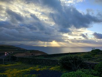 Scenic view of agricultural field against dramatic sky