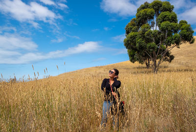 Young couple on field against sky