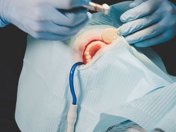 Midsection of dentist examining person mouth