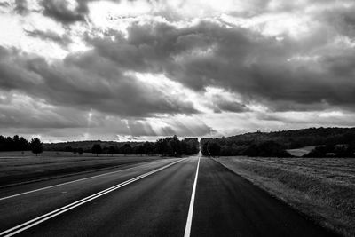 Empty road against cloudy sky