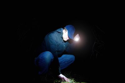 Rear view of man working at night