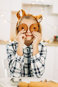 Portrait of girl holding ice cream at home