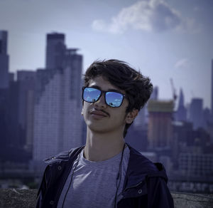 Portrait of teenage girl wearing sunglasses against sky