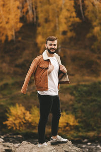 Portrait of young man standing on rock