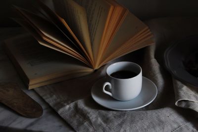 High angle view of coffee by book