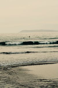 Silhouette person on beach against clear sky
