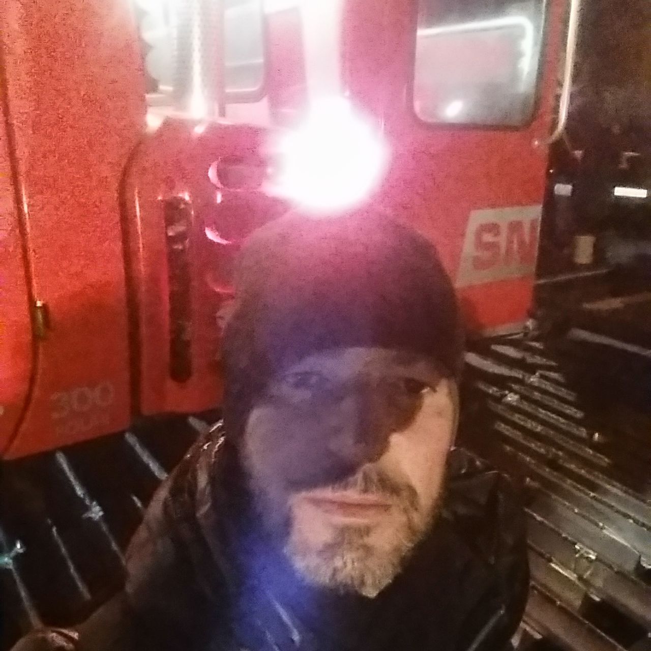 CLOSE-UP OF MAN IN TRAIN AT ILLUMINATED BUS