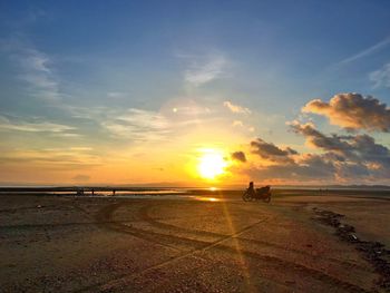 Silhouette man on beach against sky during sunset