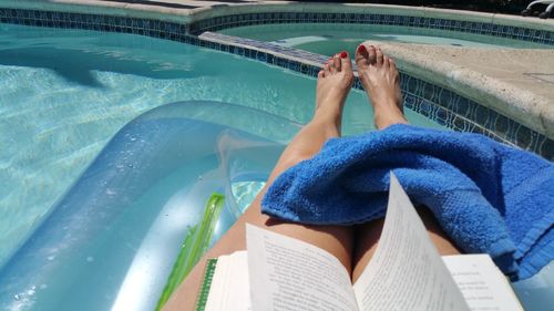 Low section of woman sitting in swimming pool