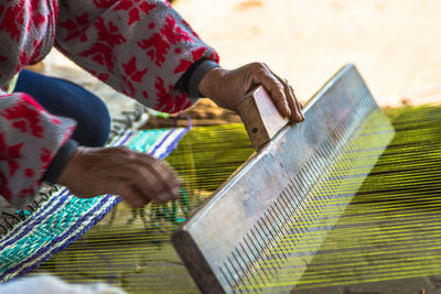 Close-up of person working at handloom