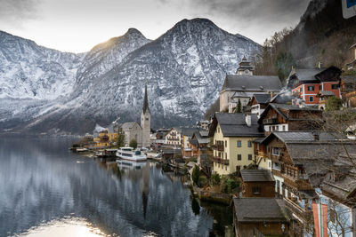 Town by mountain against sky in winter