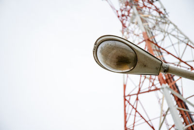 Low angle view of electric lamp against sky