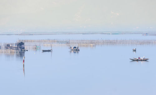 Sailboats in sea against sky