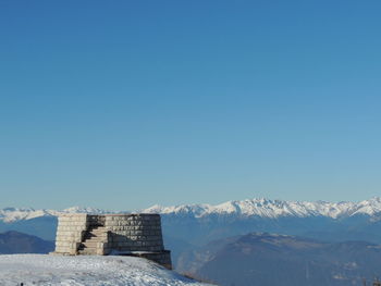 Scenic view of snowcapped mountains against clear blue sky