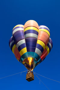 Low angle view of hot air balloon against clear blue sky