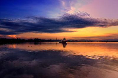 Silhouette boat in sea against sky during sunset