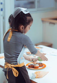 Midsection of woman having food in plate