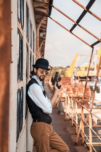 Side view of young man photographing