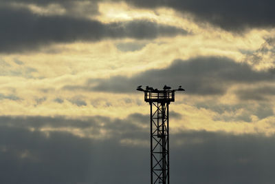 Silhouette of tower against cloudy sky