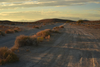 Road amidst landscape against sky during sunset