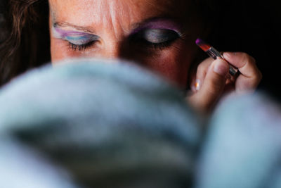 Cropped image of woman applying eyeshadow