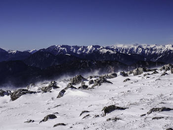 Scenic view of snow covered mountains against clear sky