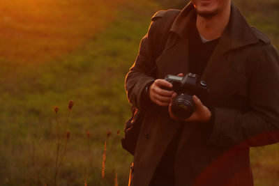 Soft focus of man photographer hold camera on sunny nature background. copy space. banner 