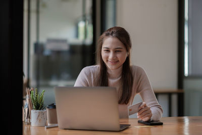 Young woman using laptop at table