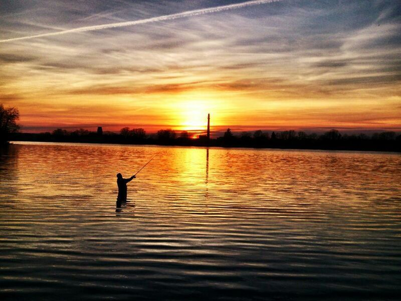 sunset, water, silhouette, reflection, sky, waterfront, lake, scenics, orange color, beauty in nature, tranquil scene, tranquility, cloud - sky, sun, nature, cloud, river, rippled, idyllic, building exterior