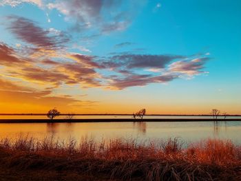 Scenic view of lake against sky during sunset