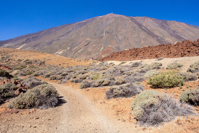 Scenic view of mountains against clear blue sky