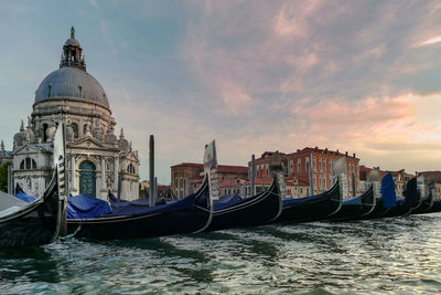 View of boats in canal amidst buildings against sky