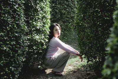 Woman with arms raised in forest