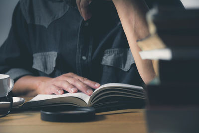 Midsection of man reading book