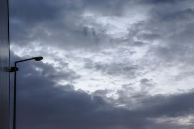 Low angle view of street light against cloudy sky