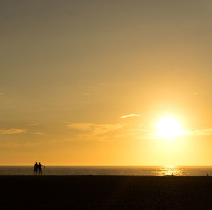 Silhouette of people on beach during sunset