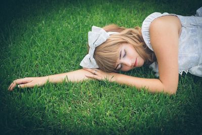 Woman lying on grassy field