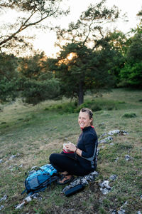 Woman having a break while hiking at sunset. 