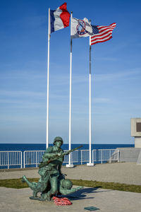 Statue by sea against sky