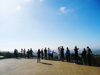 People standing against clear blue sky