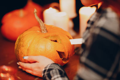Close-up of hand holding pumpkin during halloween