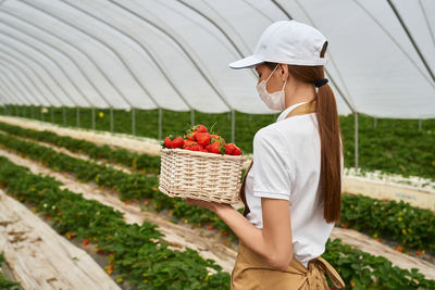 Woman holding ice cream while standing in basket