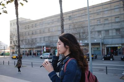 Side view of woman standing on city street