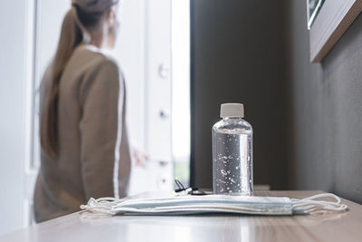 Midsection of woman standing by table at home