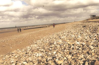 Scenic view of beach against cloudy sky