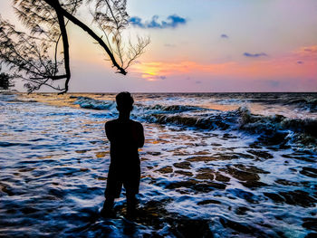 Rear view of man standing on beach