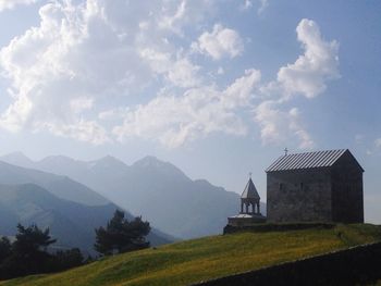 Scenic view of building by mountains against sky